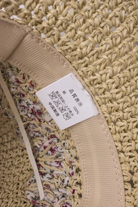 Close-up of handmade straw hat interior showing beige sweatband and floral lining