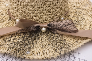 Chapeau de soleil élégant en paille tissée avec perles, voile et ruban champagne
