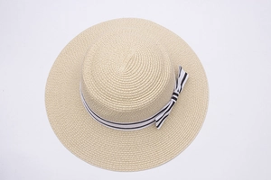 Top-down view of a beige straw sun hat with black and white striped bow ribbon detail