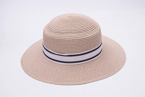 Close-up of fine straw weave texture and black-white striped ribbon on beach sun hat