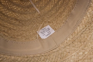 Detailed close-up showing the 100% raffia straw weave and sweatband of the sun hat