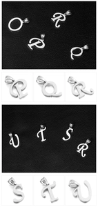 Detail of silver stainless steel alphabet pendants O to U on black and white background