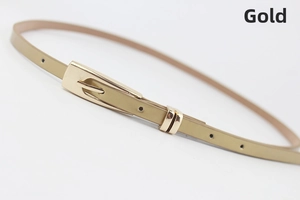 Detailed macro view of a slim gold women's belt featuring a shiny alloy buckle and texture