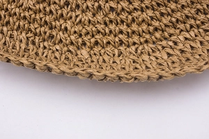 Detailed macro view of hand-crocheted paper straw texture on a summer sun hat
