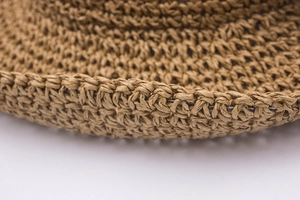 Detailed macro view of hand-crocheted raffia straw hat showing fine weaving texture