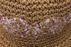 Close-up of handmade straw sun hat featuring brown woven texture and floral fabric detail