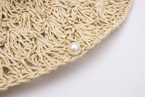 Détail d'un chapeau de paille fait main avec bordure en tulle et perle élégante