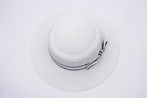 Detailed top view of white straw sun hat featuring a striped bow and fine weave texture