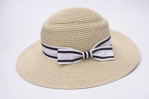 Detail view of woven straw sun hat with a white black-striped bow ribbon on the brim