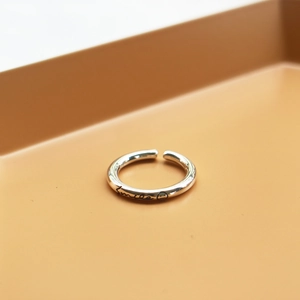 Detailed view of S925 sterling silver smile face open ring on a beige display tray