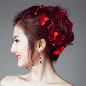 Close-up of red floral bridal headpiece with pearls and matching tassel earrings