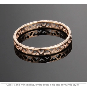 Macro shot of rose gold titanium ring featuring hollow heart cutouts with reflective finish