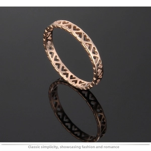 Detailed close-up of rose gold hollow heart ring with mirror reflection on black background