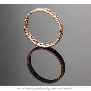 Macro detail of rose gold heart cutout ring on a dark reflective surface