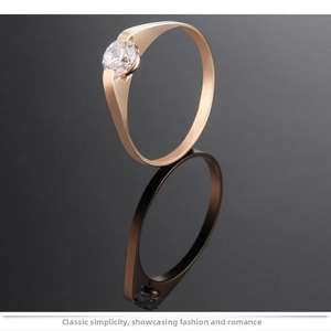 Detail of rose gold titanium ring featuring a single round zircon in a tension setting