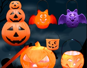 Close-up of glowing Halloween pumpkin lanterns and bat-shaped candy buckets in orange and purple