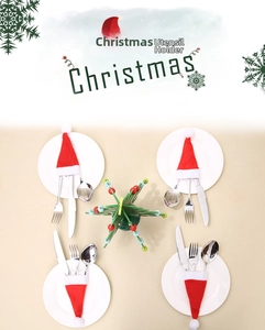 Detailed view of four mini Christmas hat cutlery holders set on a ceramic plate