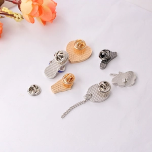 Detail view of colorful enamel pins with heart and smile motifs on metal butterfly backings