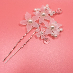 Close-up of bridal U-shaped hair pin with matte pink flowers and white pearls