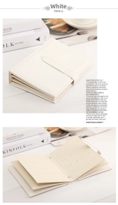 White faux leather earring storage book with snap closure and multi-page design