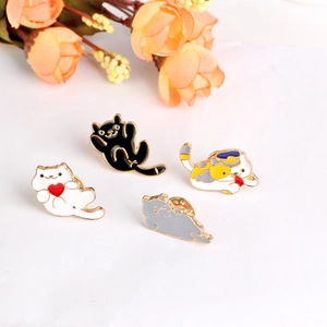 Detailed view of four colorful enamel cat pins in different cute poses on white background
