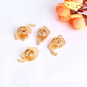 Detailed back view of four golden cat brooches showing secure butterfly clutch fasteners