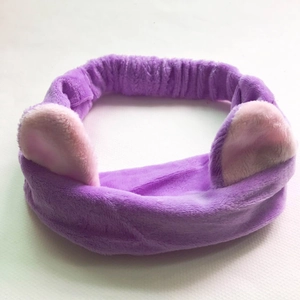 Detail of soft purple plush headband featuring pink cat ears on white background