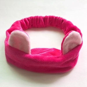 Detail view of plush pink cat ear headband showing soft fabric texture and fuzzy material