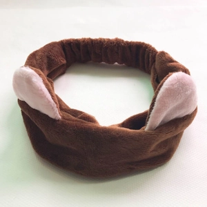 Detailed close-up of brown plush headband with pink ears on a clean white surface