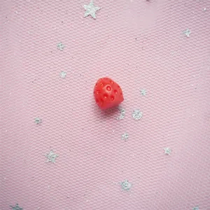 Detailed close-up of a resin red strawberry charm with textured surface for DIY crafts