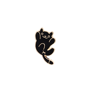 Close-up of a cute black cartoon cat enamel pin badge with elegant gold metal plating