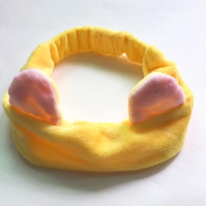 Detail of yellow plush cat ear headband made of soft coral fleece for facial cleansing