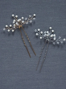 Detail of two handmade gold and silver bridal hair pins with pearls and crystal beads