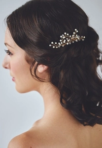 Detail of bridal hair pin with gold wire, white pearls and crystals on wavy hair