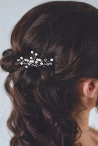 Silver bridal hair pin with pearls and crystals styled on an elegant dark updo hairstyle
