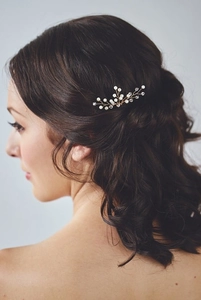 Detail of bridal hair pin with golden wire branches, pearls and crystals on dark hair