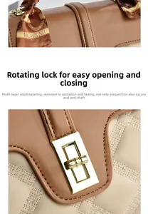 Close-up of golden rotating lock and elegant printed silk scarf on a leather handbag
