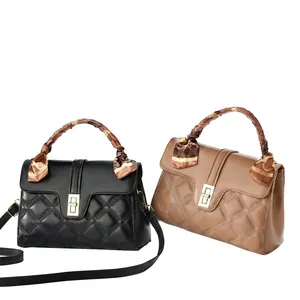 Chic quilted leather handbags in black and tan with silk scarf handles on display