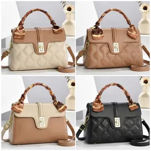 Close-up of quilted PU leather handbag with silk scarf handle and golden twist lock