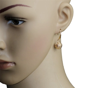 Vue détaillée de boucles d'oreilles basket dorées sur modèle avec texture rainurée