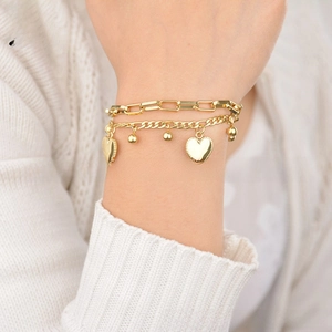 Close-up of gold double-layer stainless steel bracelet featuring a delicate heart charm