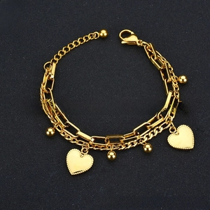 Detail of gold double-layered stainless steel heart bracelet with beads and lobster clasp