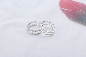 Close-up of minimalist S925 sterling silver hollow hexagonal open rings set with feather