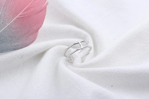 Minimalist S925 sterling silver ring with geometric hollow H design on soft white fabric