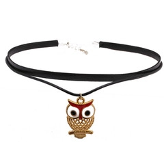 Detail of a black choker necklace featuring a golden owl pendant with red enamel accents