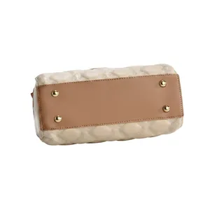 Detail view of the quilted cream leather handbag featuring protective gold base studs