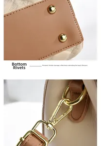 Detail view of gold base rivets and metal hooks on dual-tone leather shoulder bag