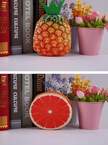 Detail of plush pineapple and orange coin purses with zipper closure and ball chain