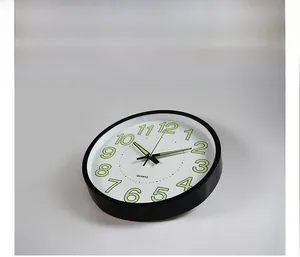 Close-up of a 12-inch luminous wall clock featuring large green numbers and quartz movement