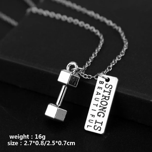Macro view of silver dumbbell pendant with Strong is Beautiful engraved metal plate